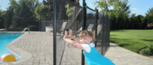 Child pushing on mesh safety fence to prove how safe it is